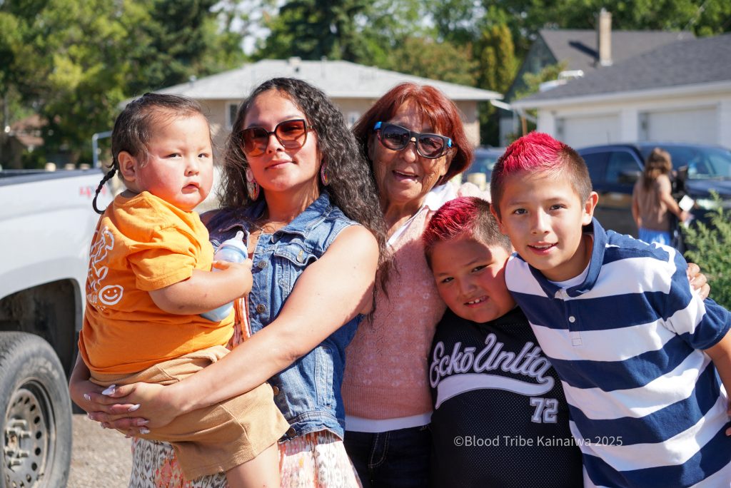 Nikeah Chief Moon (2nd from left) and her family pose for a photo after The 2025 Whoop-Up Days Parade in Lethbridge, AB., on August 19, 2025. Photo credit: Henry Heavyshield.